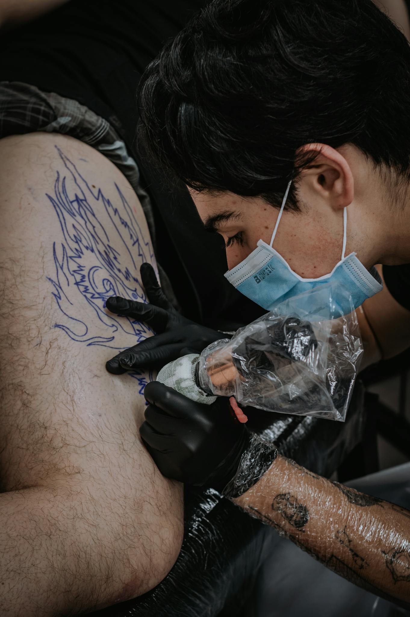 Tattoo artist focused on creating intricate design in Bogotá studio.